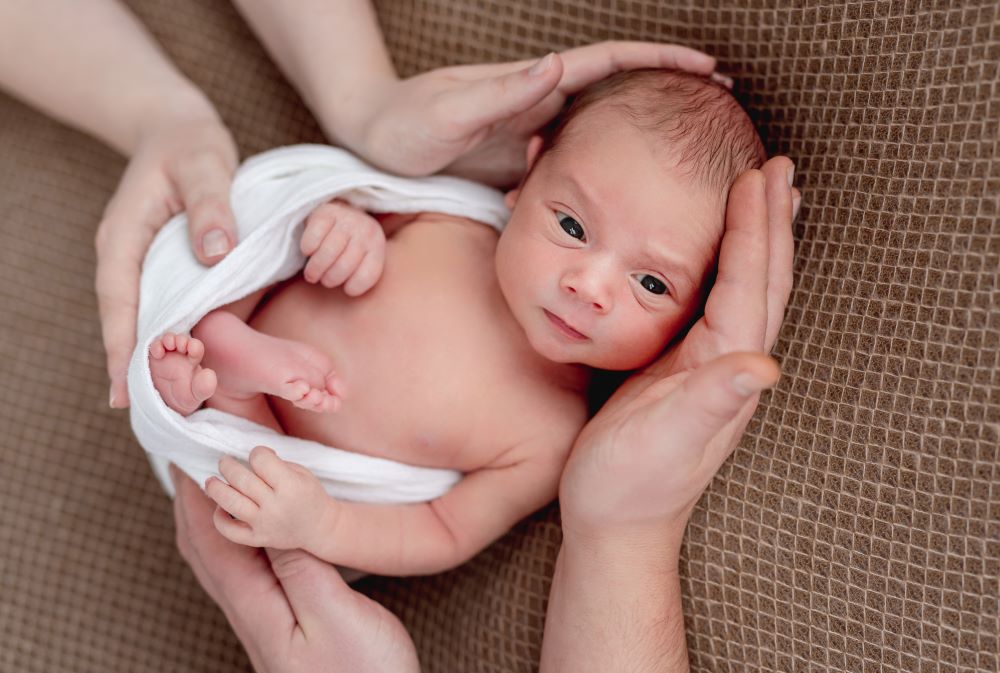 Tiny baby held in adult hands